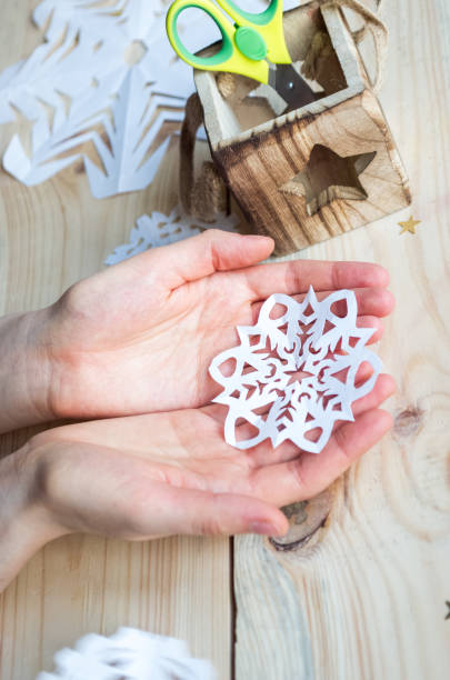 istock A snowflake made from paper with your own hands gracefully decorates a winter interior, adding warmth and a cozy atmosphere 2187491205