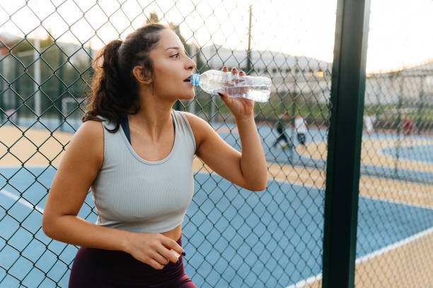 istock Refreshing Break. Woman Staying Hydrated During a Workout 2187495325