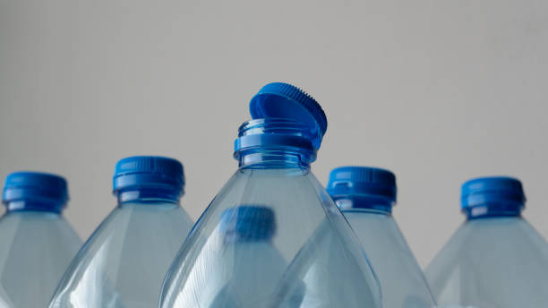 istock Several plastic bottles with blue caps are neatly arranged against a white background, highlighting the simplicity and convenience of bottled water. 2187497714