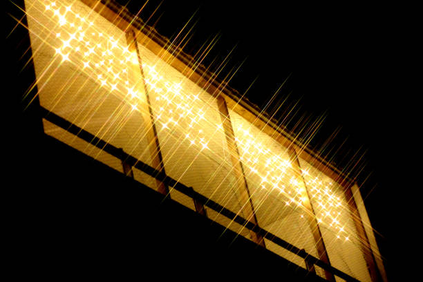 A balcony full of yellow lights shining through the night