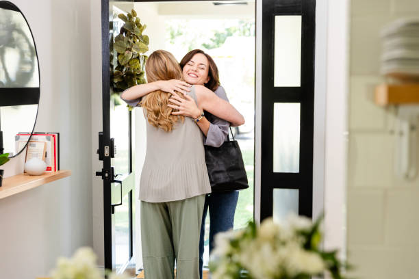 istock Two female friends embrace one another in the entryway 2187498652
