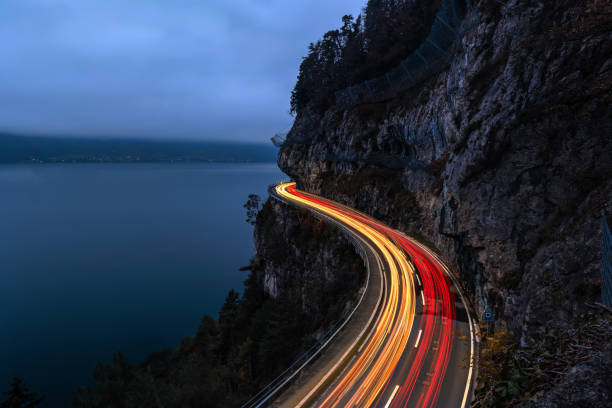 istock The spetacular motorway on cliff with traffic light trail in the evening 2187499088