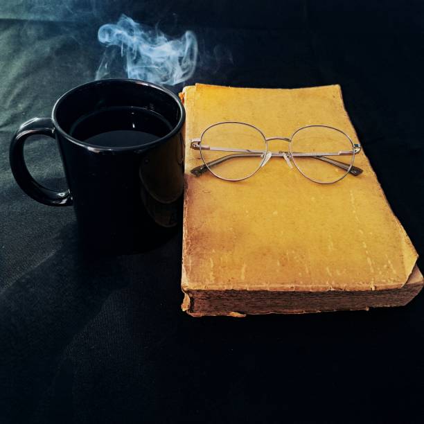 Cup of coffee and old books on a wooden table