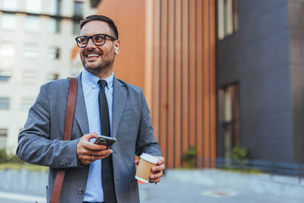 istock Smiling Businessman Using Smartphone Outside Office Building 2187502505