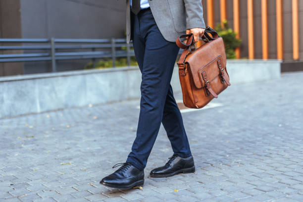 istock Man Walking on Street with Leather Briefcase and Formal Attire 2187502516