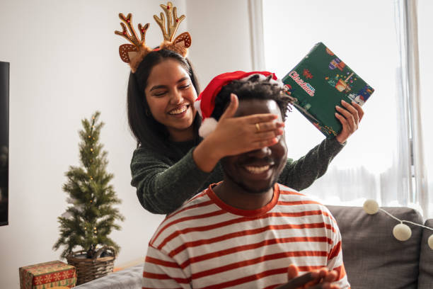 istock Couple sharing Christmas surprise gift at home 2187502526