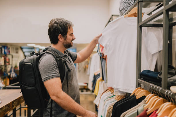 istock Man choosing t-shirt in store 2187505485