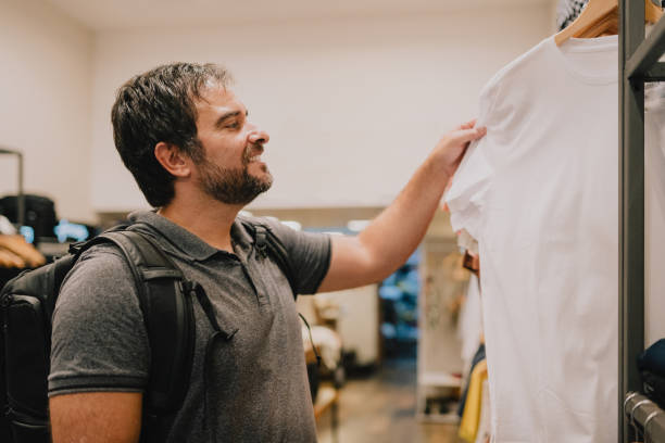 istock Man choosing t-shirt in store 2187505490