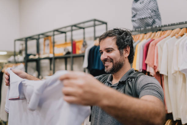 istock Man choosing clothes in store 2187505492