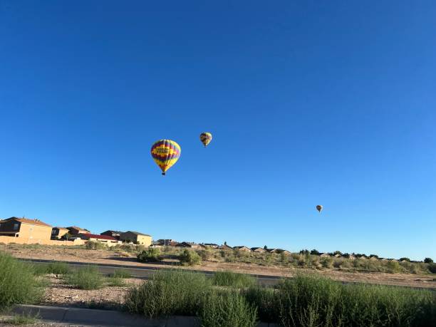Vivid, multicolored hot air balloon rising over lake in Colorado Springs CO in the early morning hours
