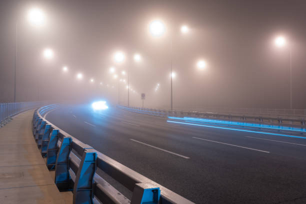 istock Light trail over the bridge highway at a fog night. 2187515370