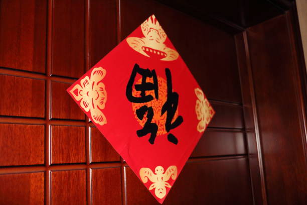 istock Decorative red banner with black calligraphy displayed on a wooden wall during a cultural celebration in a home setting 2187529281