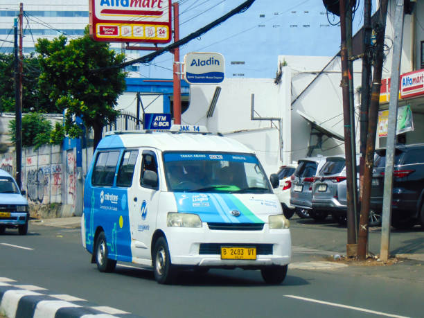 Jakarta, Indonesia - Nov 27, 2024: A front view of Mikrotrans Jaklingko public transportation by Transjakarta on the road.