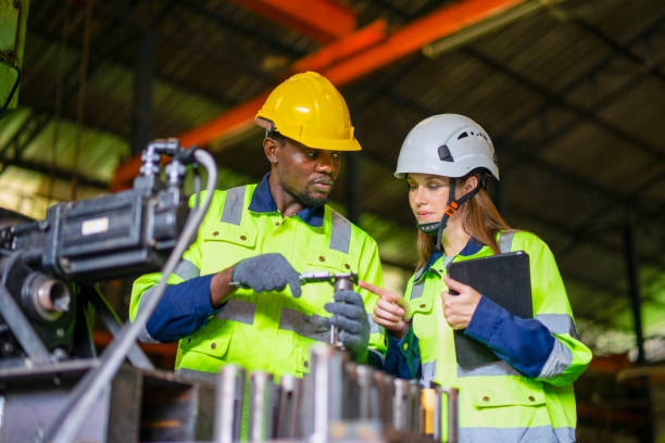 Blue collar workers are working at metal work factory.