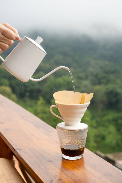 istock Hot water being poured from a white kettle into a pour-over coffee filter 2187534878