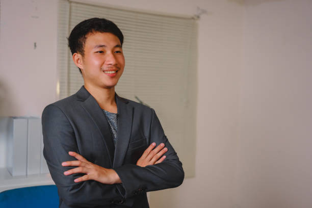 istock A successful businessman stands at his desk, smiling happily after completing his tasks for the night. His expression reflects accomplishment, satisfaction, and a positive work ethic 2187536810