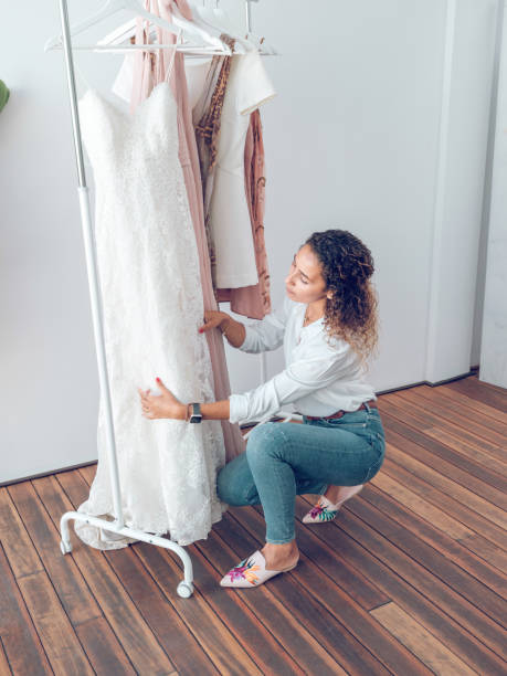istock Woman touching white dress hanging on rack 2187537046