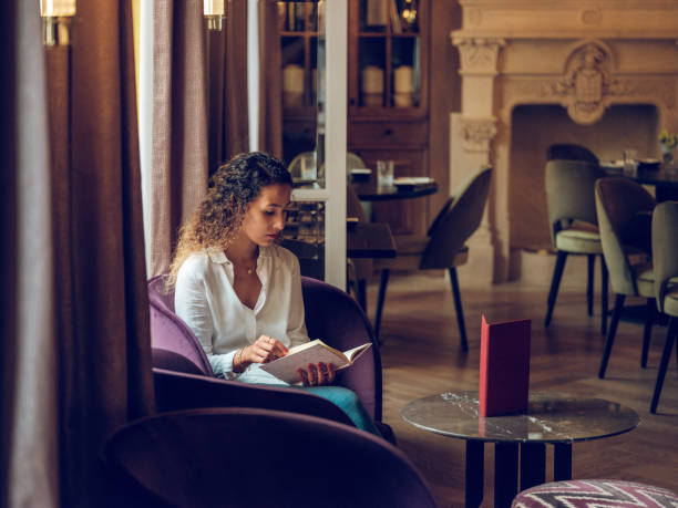istock Concentrated woman reading book in cafe 2187537182