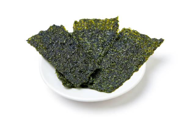 istock Crispy fried seaweed place on white dish isolated on white background. Algae are plants that grow in lakes, rivers, and other bodies of water. Seaweed has many benefits and is a snack for weight loss. 2187540143
