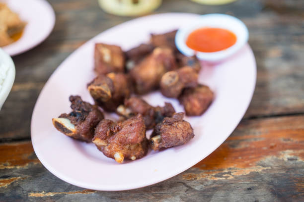 Fried pork ribs on pink dish served with chilli sauce. This menu looks appetizing