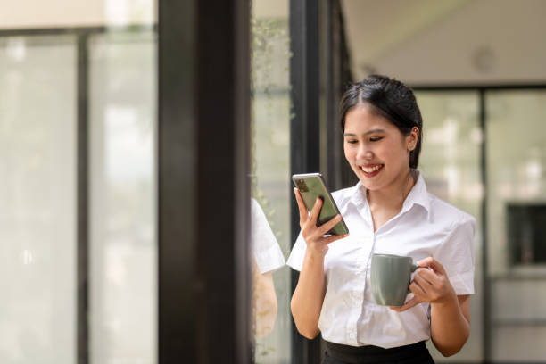 istock Happy businesswoman using the phone during break with coffee 2187541965