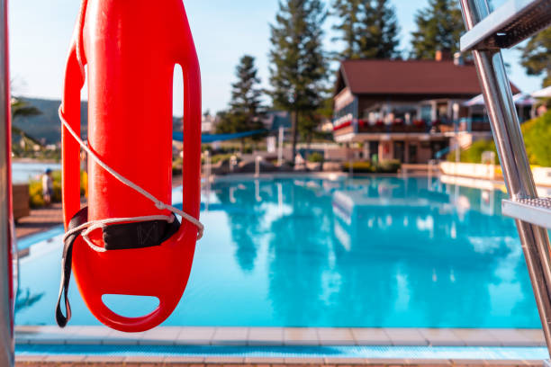 istock A red life preserver is hanging on a metal pole next to a pool 2187542098