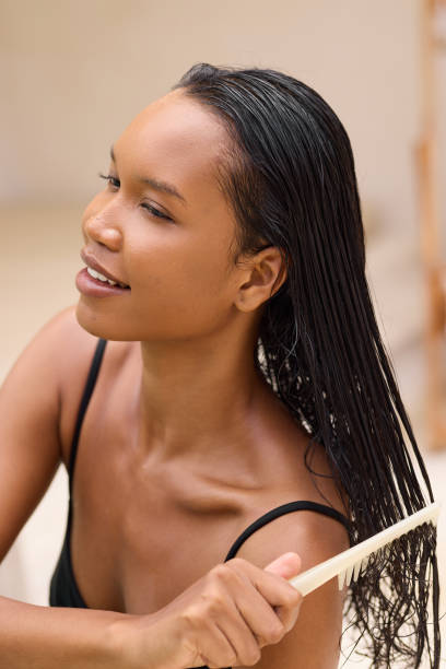 istock Young Woman Gently Combing Wet Hair in Relaxing Home Setting 2187542259