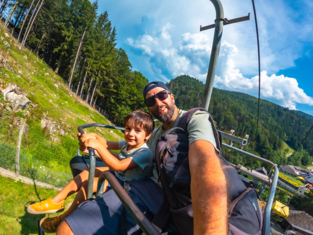 A man and a child are sitting on a ski lift