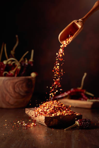 istock Chilli flakes are poured into a wooden dish. 2187543883