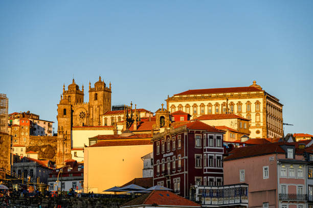 Porto, Portugal - July 23, 2024: Urban cityscape including the cathedral towers. Golden light of the late afternoon.
