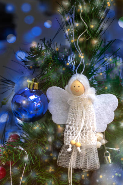 istock White hand-made angel decorates Christmas tree 2187546339