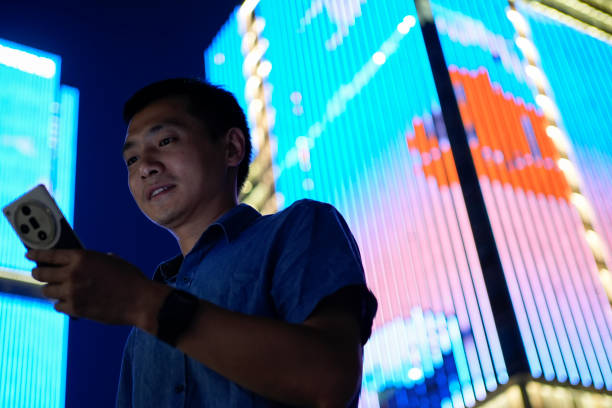 istock Young Asian men use tablets under the building at night 2187548542