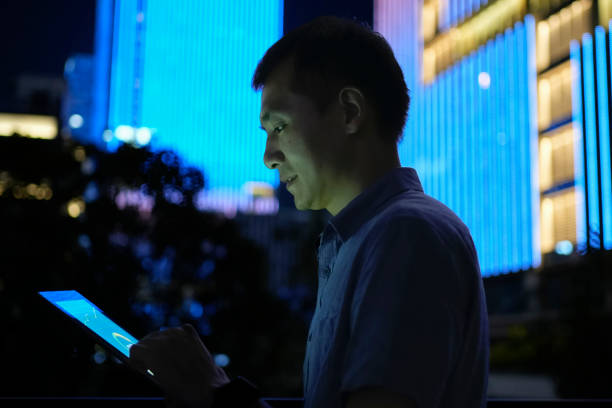 istock At night, young Asian men use tablet computers under the building to view data graphs 2187548546