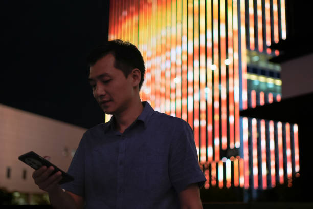 istock Young Asian men use tablets under the building at night 2187548561