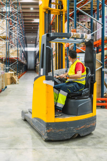 istock Warehouse worker driving forklift through aisles of storage racks 2187549166