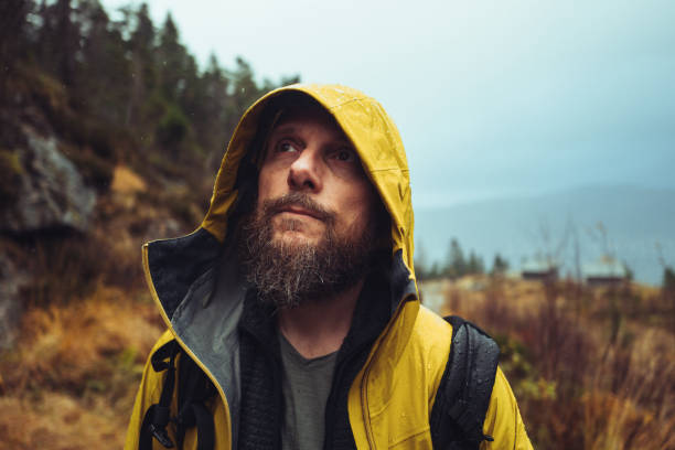 Forest ecosystem: outdoors in forest  during autumn. Man hiking on a trail during a dark rainy day of winter