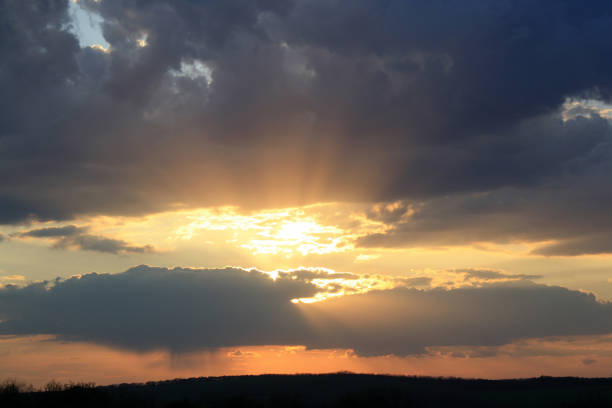 a sunset with clouds and a sun in the sky