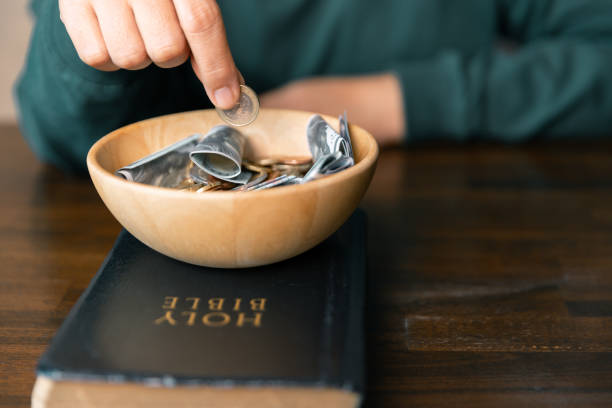 istock He decided to donate portion of his earnings as tithe, giving money and coins as contribution to support financial needs of community. beg, quest, request, desire, need, problem, share, charitable 2187551433