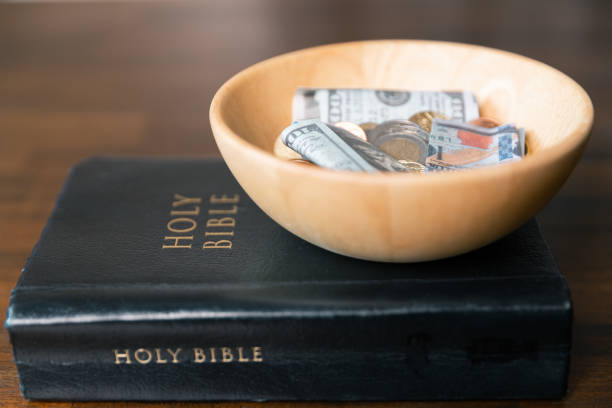 istock Idea of giving tithe as an offering to charity filled him with hope and peace, as he donated money with faith in making positive impact. book, financial, believe, spiritual, currency, wealth, coin 2187551448
