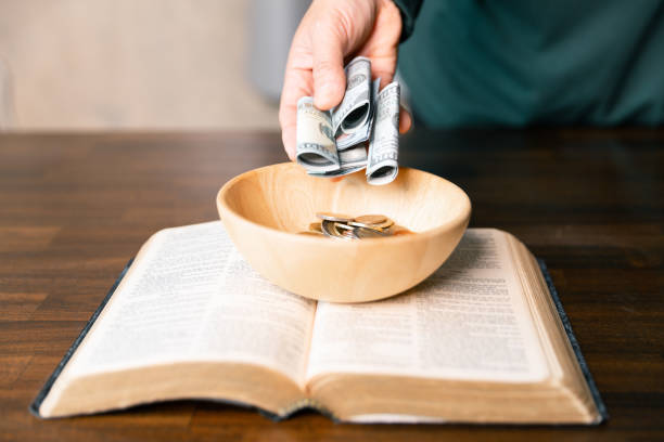 istock He decided to donate portion of his earnings as tithe, giving money and coins as contribution to support financial needs of community. beg, quest, request, desire, need, problem, share, charitable 2187551496