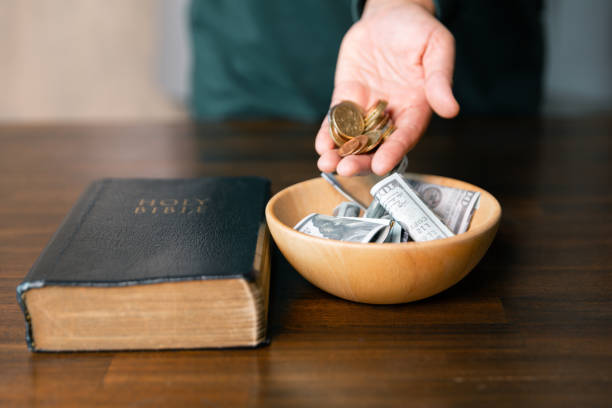 istock He decided to donate portion of his earnings as tithe, giving money and coins as contribution to support financial needs of community. beg, quest, request, desire, need, problem, share, charitable 2187551498