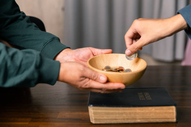 istock He decided to donate portion of his earnings as tithe, giving money and coins as contribution to support financial needs of community. beg, quest, request, desire, need, problem, share, charitable 2187551584