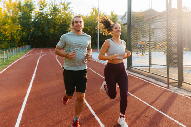 istock Young man and woman run at stadium 2187551646