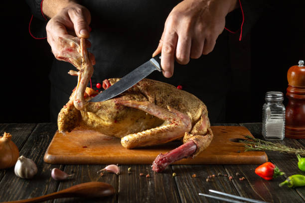 istock In a warm, dimly lit kitchen, hands expertly carve a beautifully roasted duck. Fresh herbs and spices add vibrant colors and aromas, enhancing the culinary atmosphere 2187552509