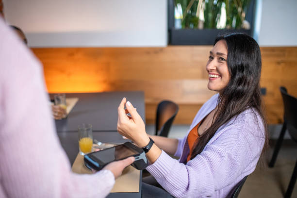 istock Caucasian Woman Pays with Wearable Tech at Eatery 2187552541