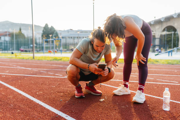 istock Young woman and man hanging out while doing sport training at the stadium 2187552908