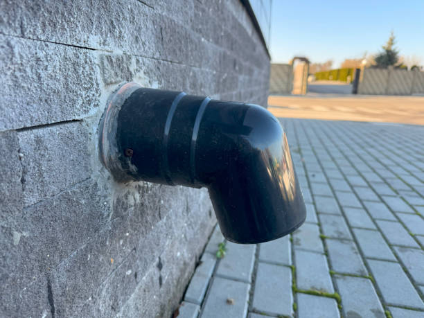 istock A plastic pipe for water drainage extends down the side of a multi-story building. The pipe is smooth and cylindrical, running vertically along the facade 2187557793