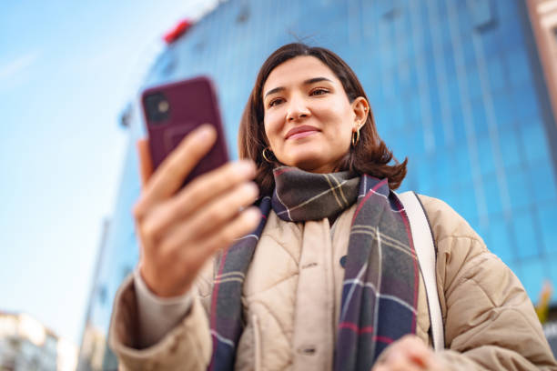istock Woman using mobile phone in city street. 2187558164