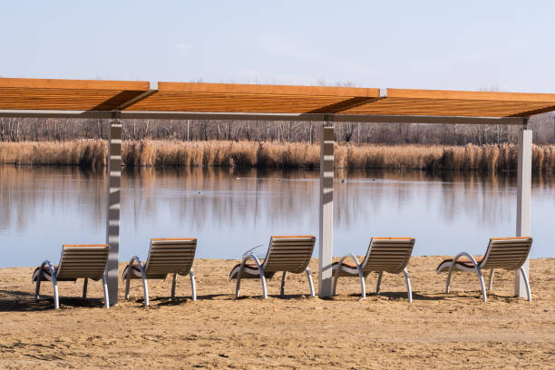 Red chair on a bank of Ada lake with cloud reflections in a water at summer morning, Belgrade, Serbia