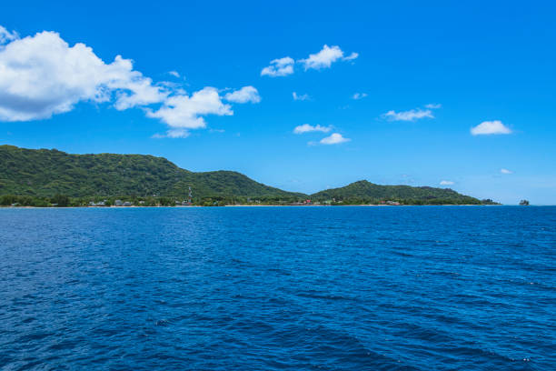 A beautiful view of Atauro Island in Timor-Leste, a tropical paradise. The clear sea with gradients of turquoise and blue stretches out before the island's charming, hilly coastline.